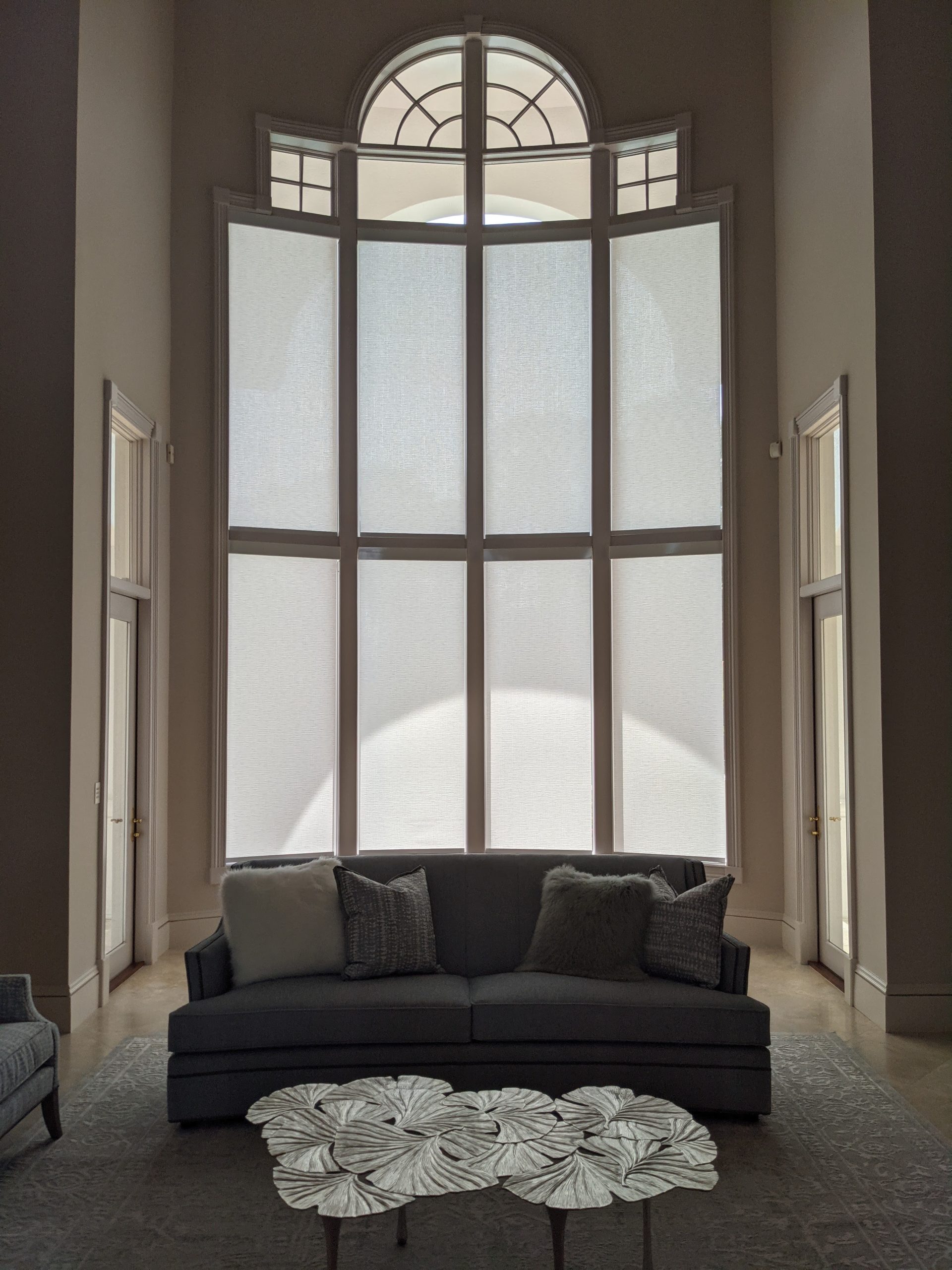 Living room with arched windows and modern roller shades